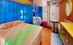 Colorful hotel room with bed and bunkbeds